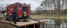 przedstawia dwóch funkcjonariuszy JRG Chełmno oraz pojazd GCBA z JRG Chełmno podczas poboru wody z punktu czerpania wody nr 2 Nadleśnictwa Jamy w miejscowości Klamry