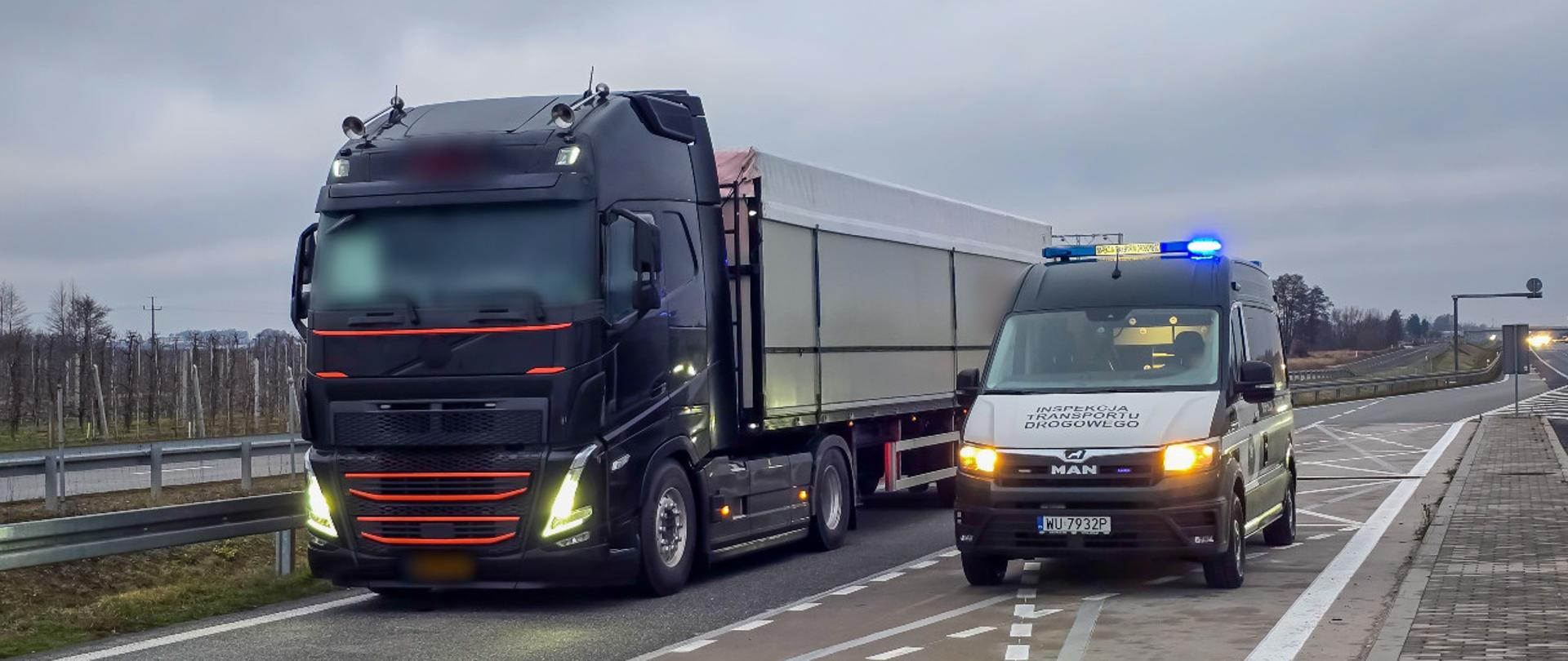 Od lewej: ciągnik siodłowy z podpiętą naczepą typu wywrotka stoi w zatoce kontrolnej przy ekspresowej „siódemce” pod Grójcem. Obok stoi oznakowany furgon mazowieckiej Inspekcji Transportu Drogowego z włączonymi niebieskimi światłami uprzywilejowania.
