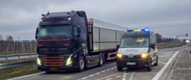 Od lewej: ciągnik siodłowy z podpiętą naczepą typu wywrotka stoi w zatoce kontrolnej przy ekspresowej „siódemce” pod Grójcem. Obok stoi oznakowany furgon mazowieckiej Inspekcji Transportu Drogowego z włączonymi niebieskimi światłami uprzywilejowania.