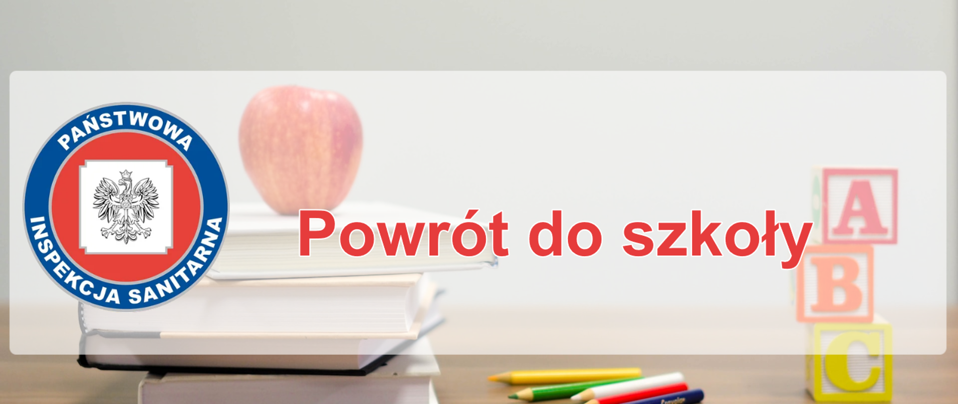 Stół, książki, jabłko, kredki, litery ABC w formie kostek