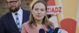 Minister funduszy i polityki regionalnej Katarzyna Pełczyńska-Nałęcz stoi przed mikrofonami dziennikarzy
