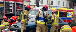 Strażacy i ratownicy medyczni w trakcie przeprowadzania pokazu ratownictwa z wykorzystaniem profesjonalnego sprzętu technicznego i hydraulicznego. Inscenizacja wypadku z udziałem motocyklistów.