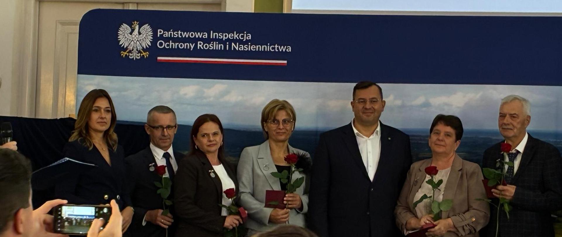 Uczestnicy Konferencji 150-lecia laboratoryjnej oceny nasion stojący przy banerze.