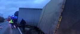 miejsce zdarzenia DK11 widoczny samochód ciężarowy tandem z przyczepą ora służby działające na miejscu policja i straż pożarna.