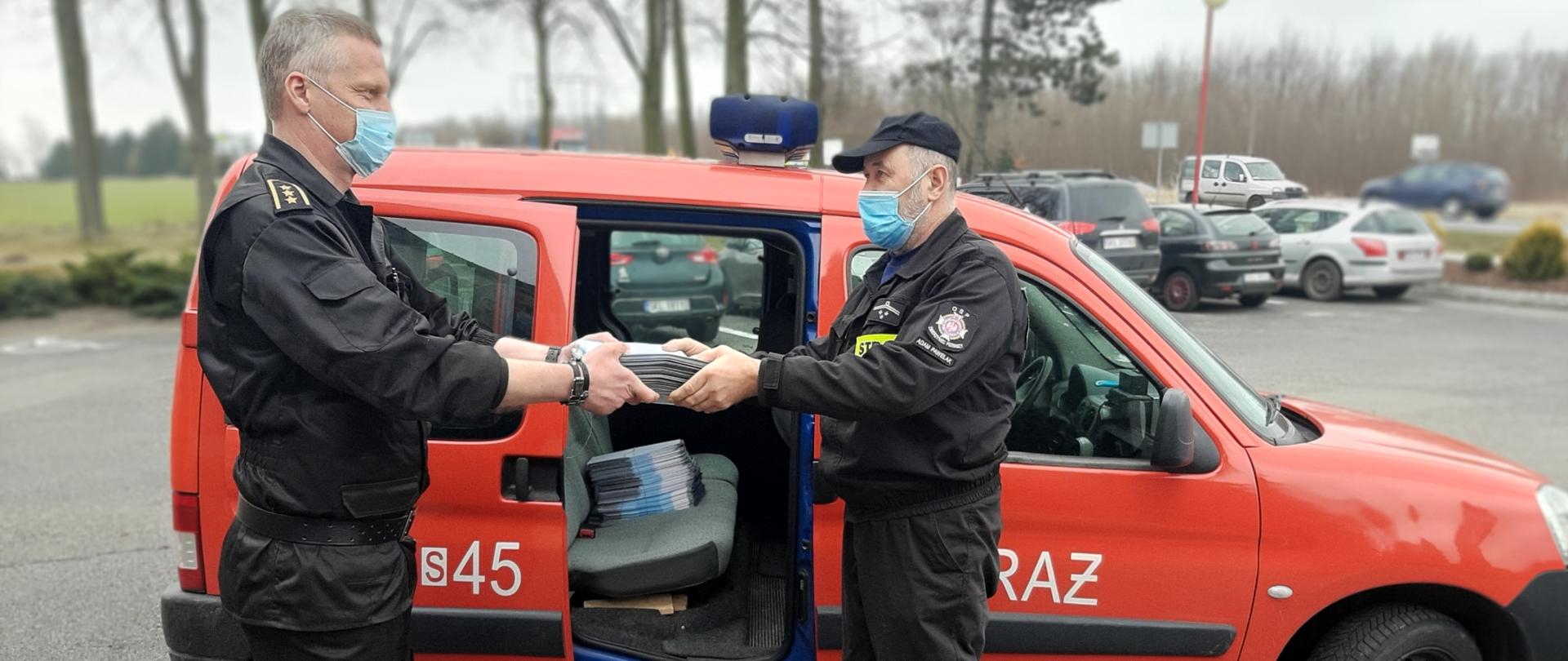 Zdjęcie przedstawia przekazanie ulotek przez funkcjonariusza KP PSP Kłobuck Prezesowi OSP Zwierzyniec Pierwszy