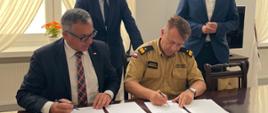 Zdjęcie wykonane w Ministerstwie Spraw Wewnętrznych i Administracji. Na zdjęciu widać moment podpisania umów z Wojewódzkim Funduszem Ochrony Środowiska i Gospodarki Wodnej na dofinansowanie zakupu pojazdów oraz sprzętu specjalistycznego. Komendę Wojewódzką PSP reprezentował mazowiecki Komendant Wojewódzki PSP w Warszawie - nadbryg. Jarosław Nowosielski. Wojewódzki Fundusz Ochrony Środowiska i Gospodarki Wodnej w Warszawie reprezentował natomiast Prezes Zarządu Pan Marek Ryszka. Za sygnatariuszami z tyłu znajdują się Sekretarz Stanu w MSWiA Pan Maciej Wąsik oraz Szef Gabinetu Politycznego w MSWiA Pan Michał Prószyński.