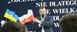 Minister Przemysław Czarnek mówi do mikrofonu, przed nim siedzą uczestnicy spotkania.