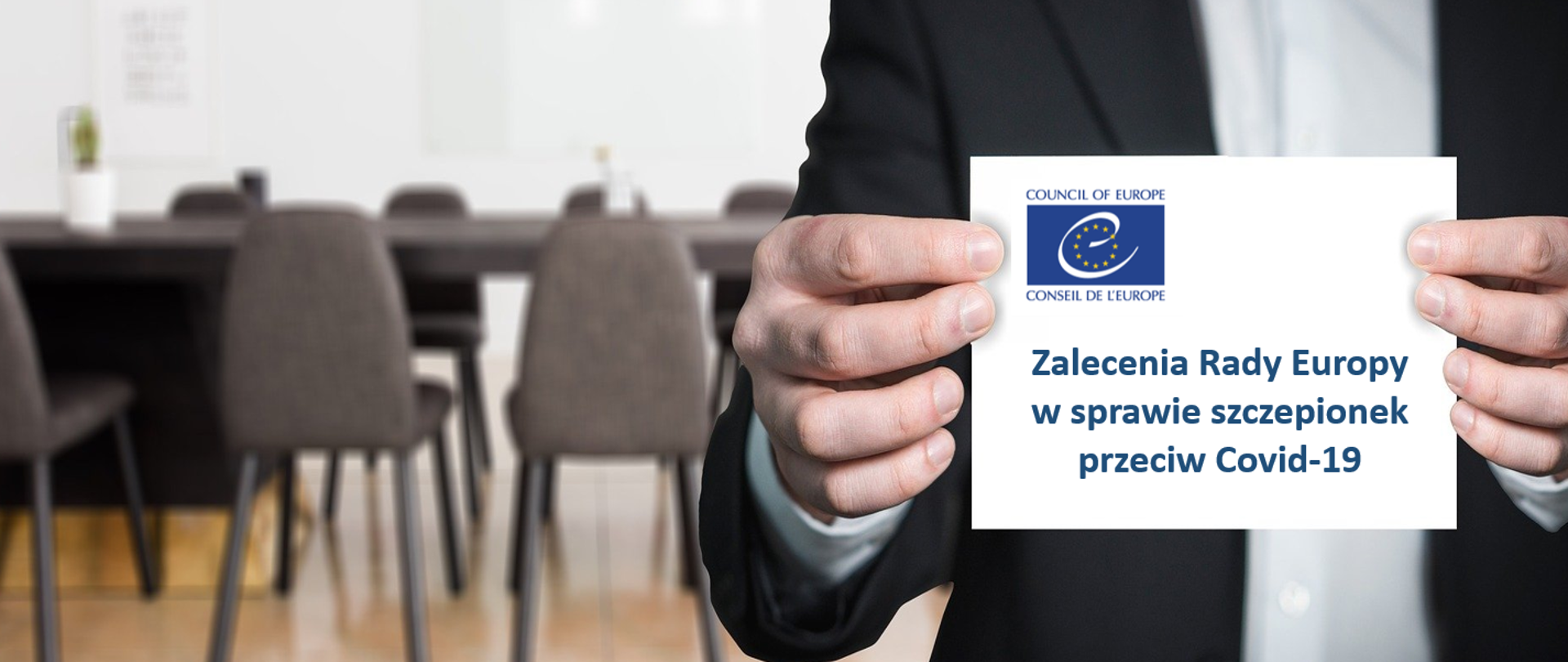 mężczyzna trzymający kartkę, na której znajduje się informacja.