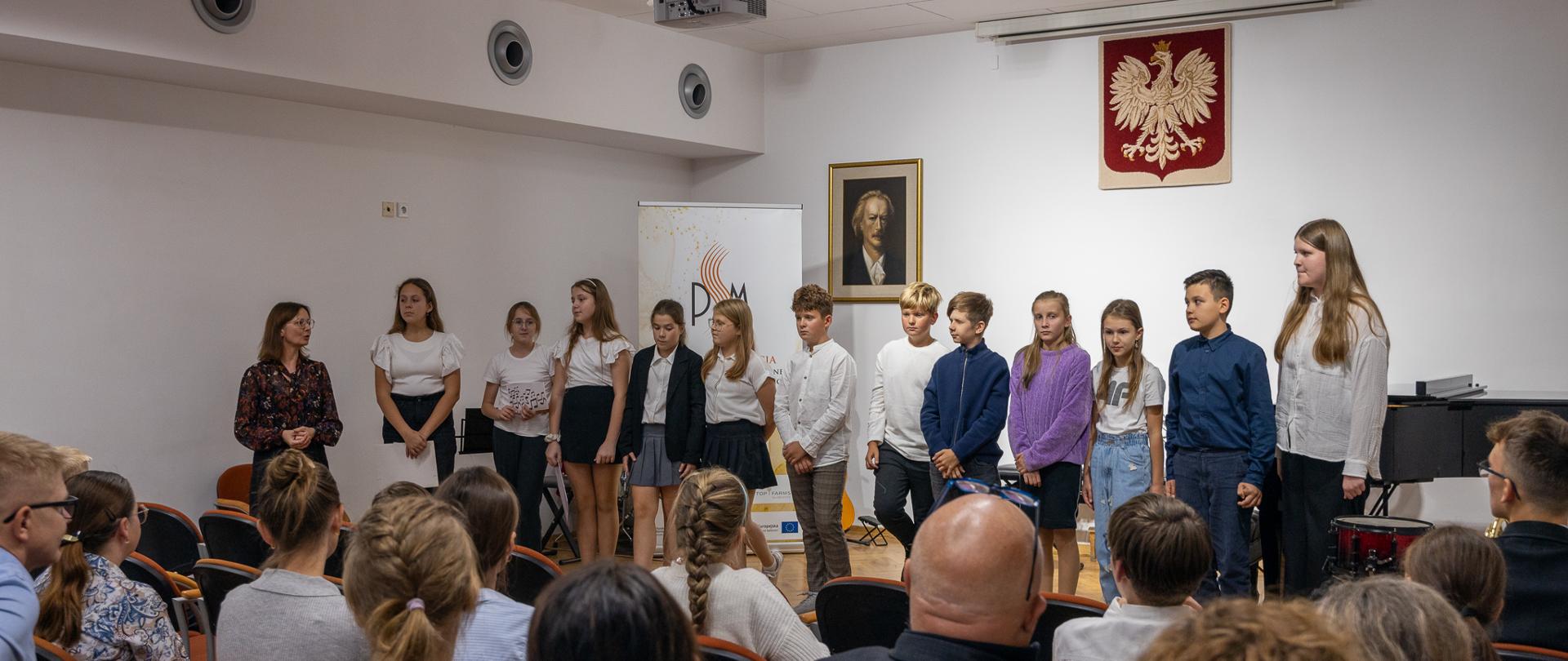 Międzynarodowy Dzień Muzyki 2024 - koncert. Zdjęcie grupowe wykonawców i uczniów zaangażowanych w przygotowanie koncertu.