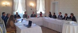 Spotkanie przedstawicieli słowackiego i polskiego dozoru jądrowego: na zdjęciu obie delegacje siedzą przy stole i rozmawiają.