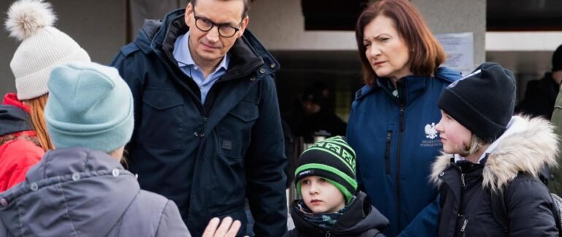 Premier Mateusz Morawiecki i wojewoda podkarpacki Ewa Leniart rozmawiają z uchodźcami z Ukrainy.