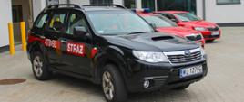 Samochód operacyjny Subaru Forester - KP PSP w Legionowie. Zdjęcie przed budynkiem KP PSP w Legionowie samochód koloru czarnego z czerwonym paskiem na boku. Na paski numer operacyjny 470M90