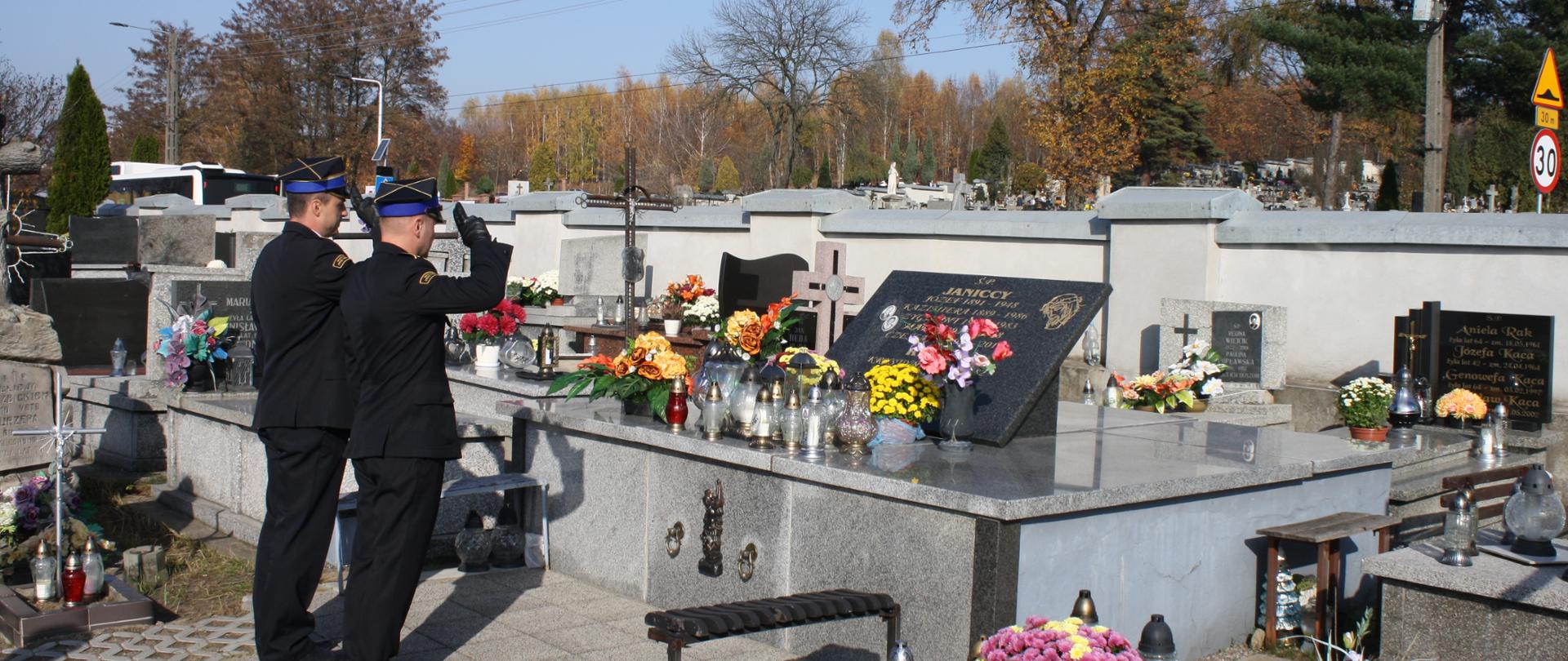 2 oficerów straży oddają honor przed pomnikiem 