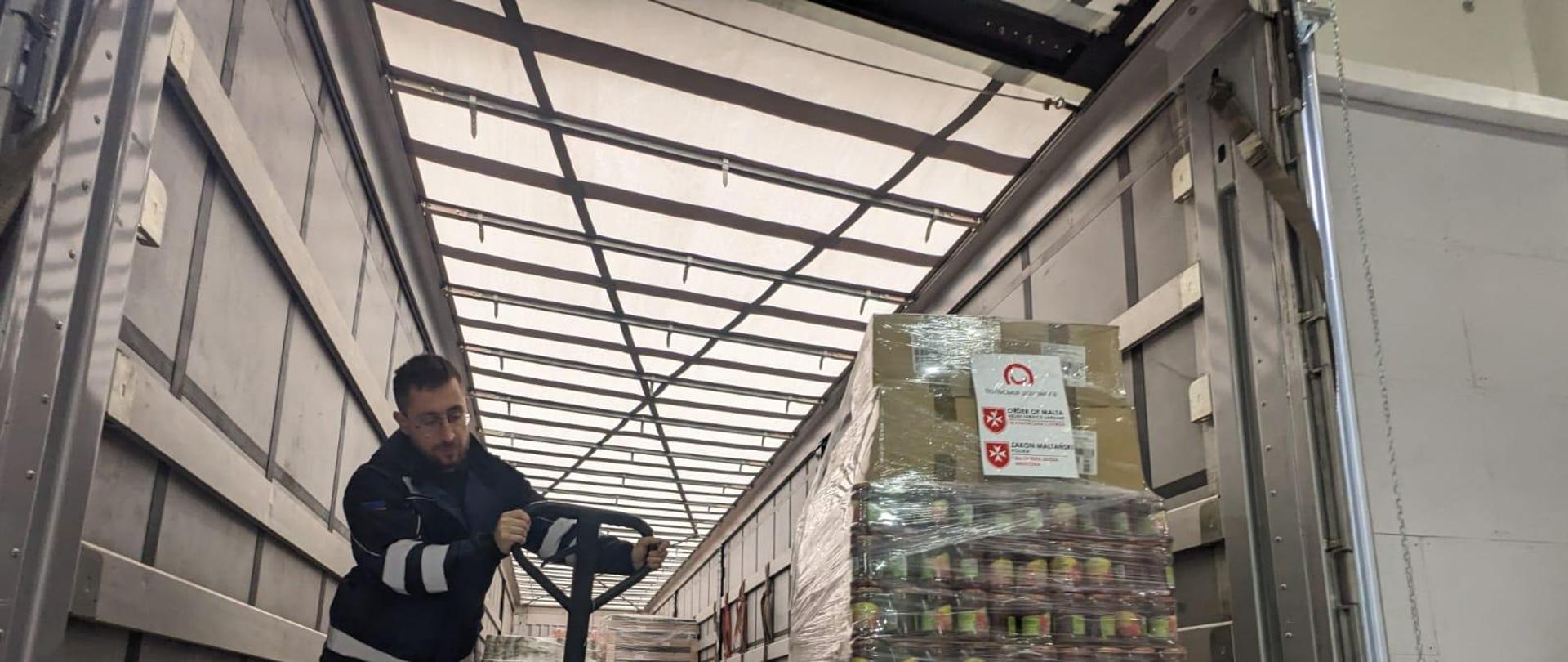 Man carefully stacking boxes in the back of a truck.