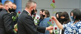 Małopolski Komendant Wojewódzki PSP wręcza róże kobietom.