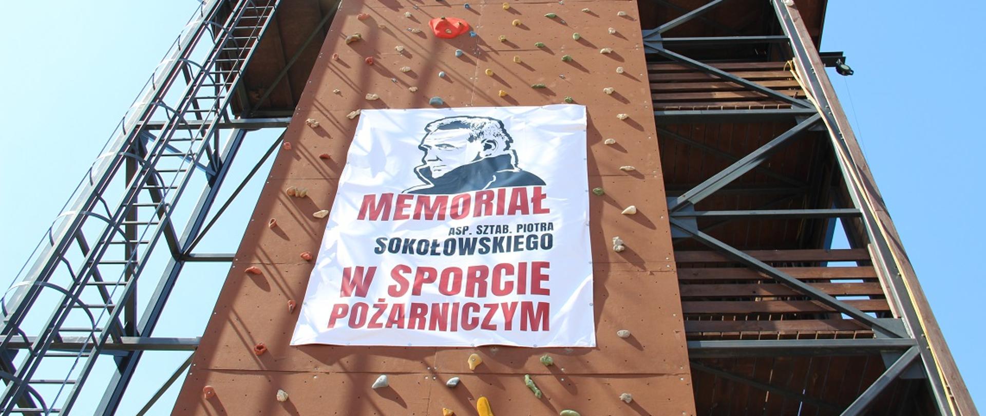 wspinalnia strażacka, na której wisi plakat z wizerunkiem asp. sztab. Piotra Sokołowskiego