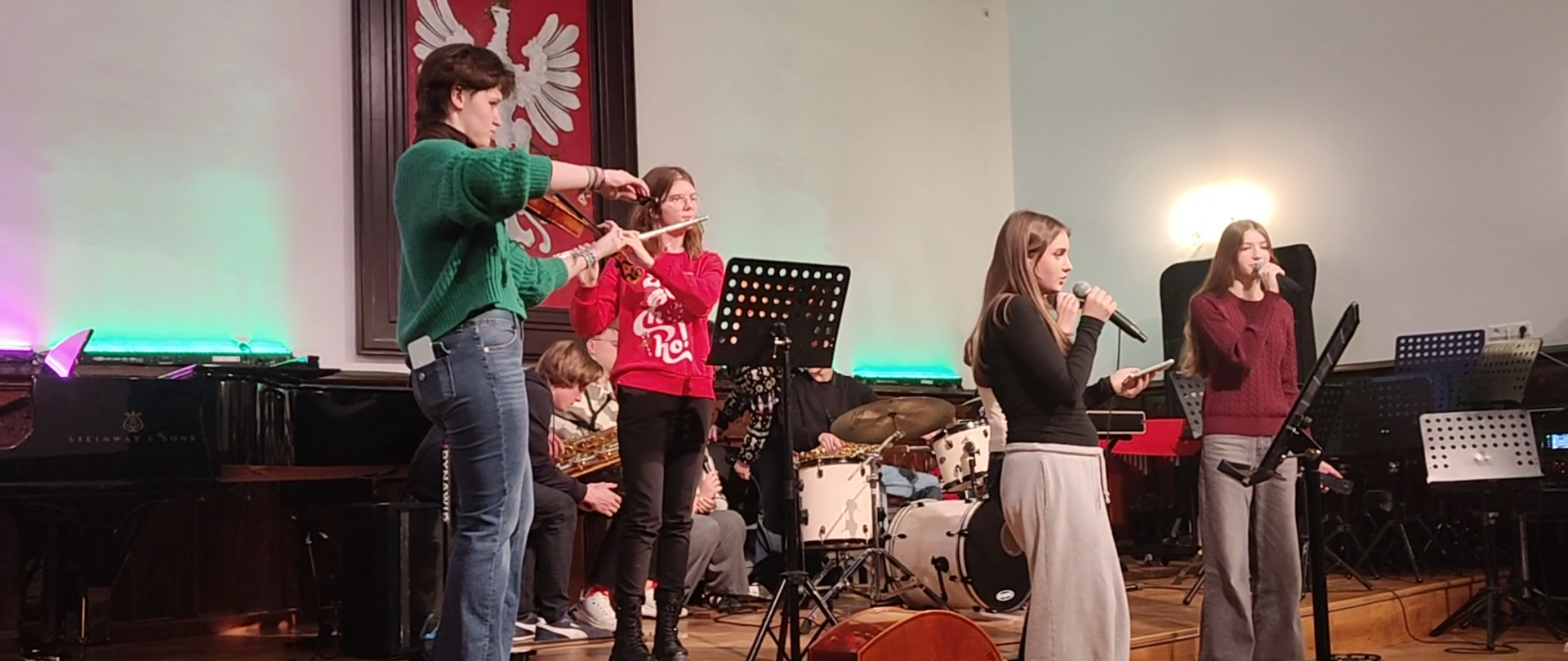 uczennice i uczniowie podczas wigilii szkolnej na scenie w sali królewskiej PSM Mielec