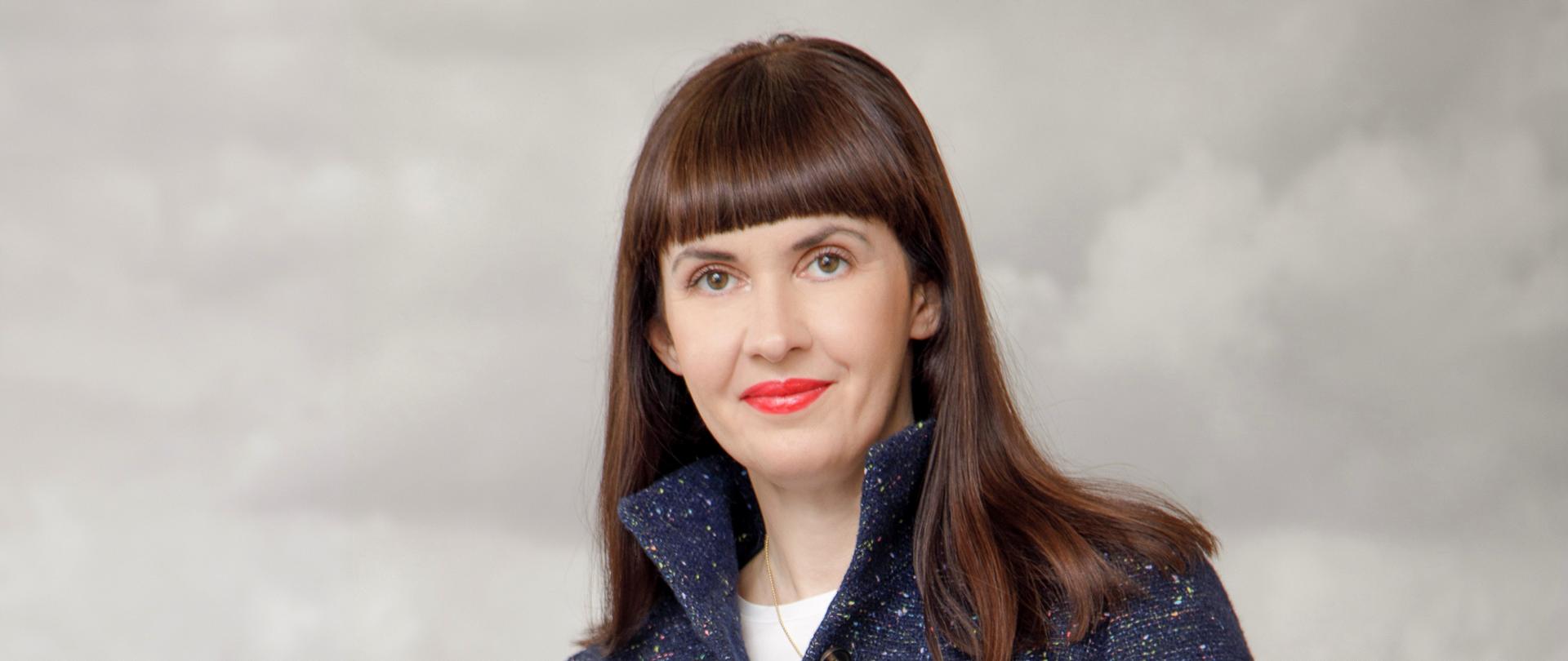 Kobieta w marynarce i ciemnych spodniach