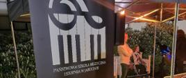 Zdjęcie przedstawia roll-up reklamujący PSM I stopnia w Jarocinie. W tle scena podczas koncertu z okazji Nocy Muzeów 2023.