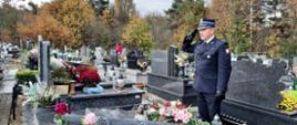 Komendant Powiatowy PSP w Żywcu oddaje honor nad grobem strażaka. 