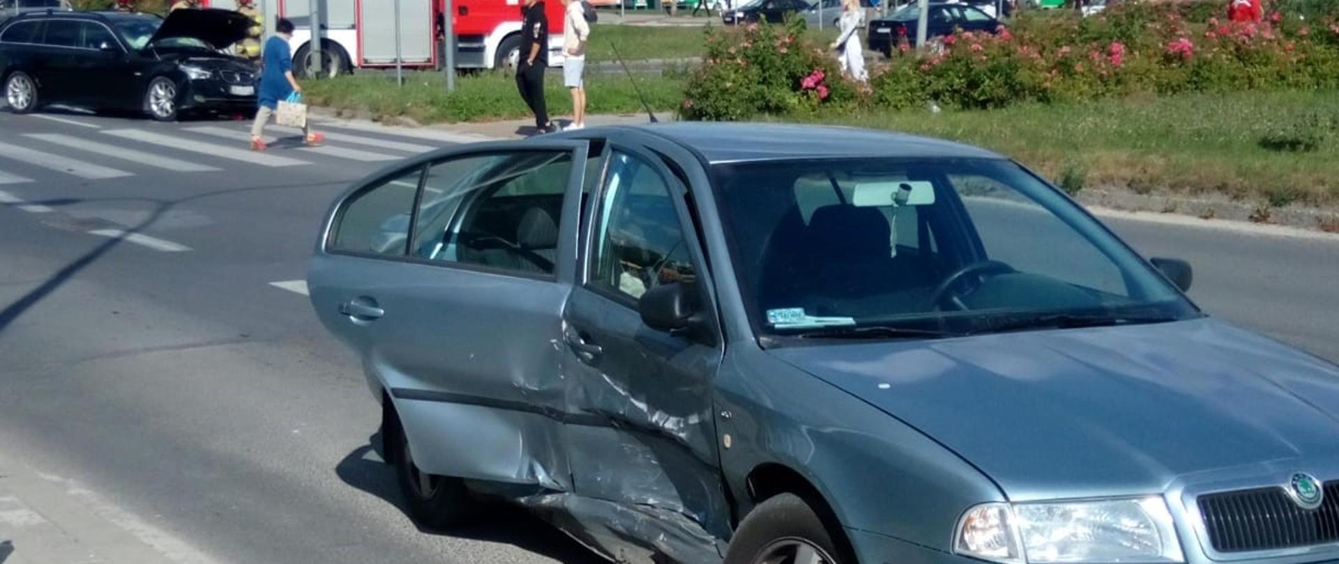 Zdjęcie przedstawia perspektywę ulicy Jagiellońskiej. Na pierwszym planie pierwszy ze zniszczonych w wyniku kolizji aut a w głębi drugi zniszczony pojazd.