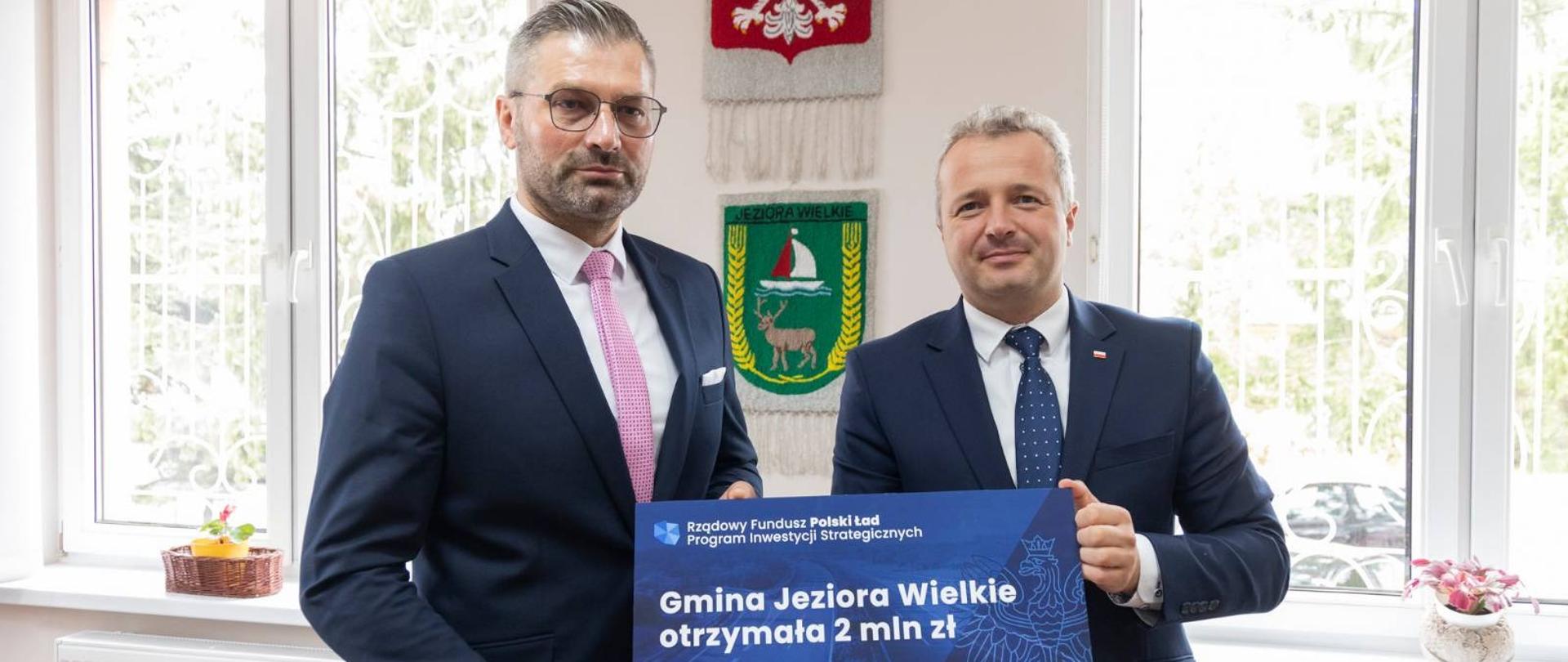 Dwóch mężczyzn trzymających voucher