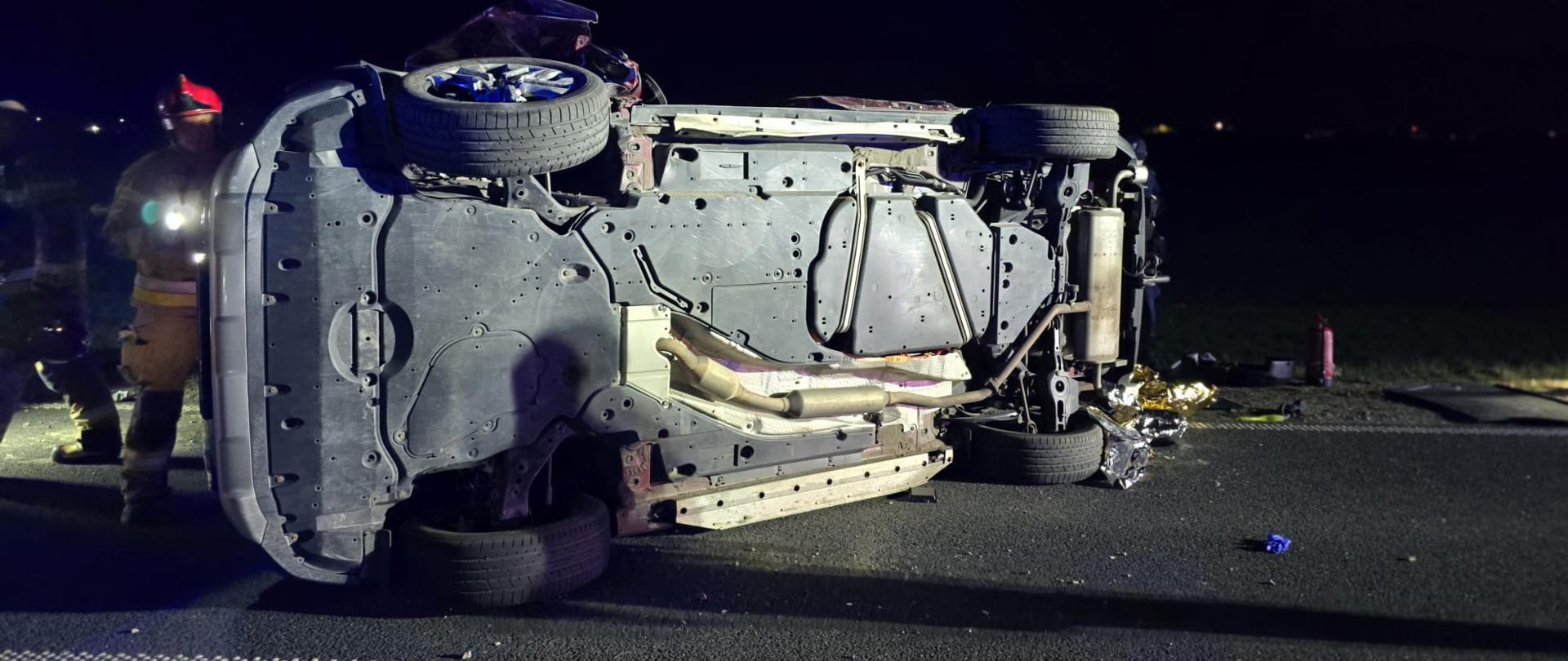 Samochód na prawym boku na drodze, jest noc