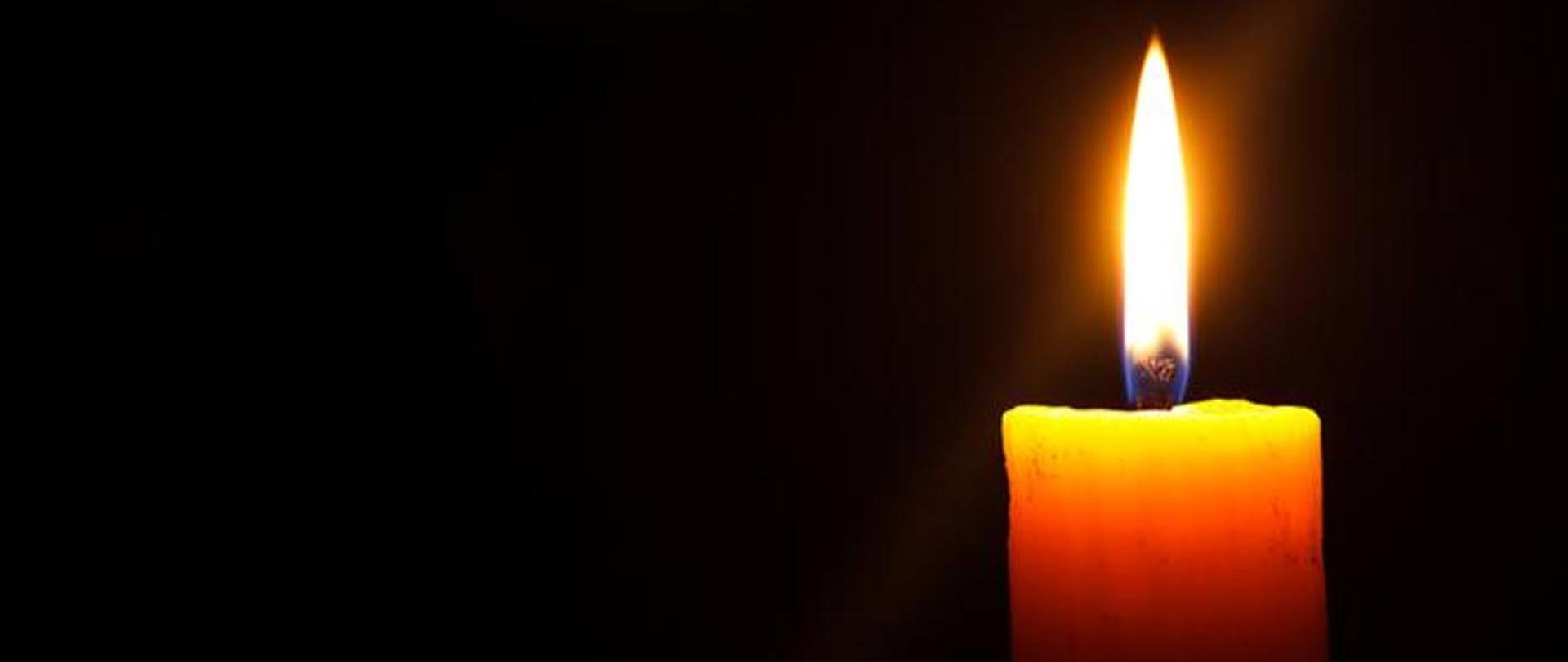 Zdjęcie płonącej świeczki na czarnym tle