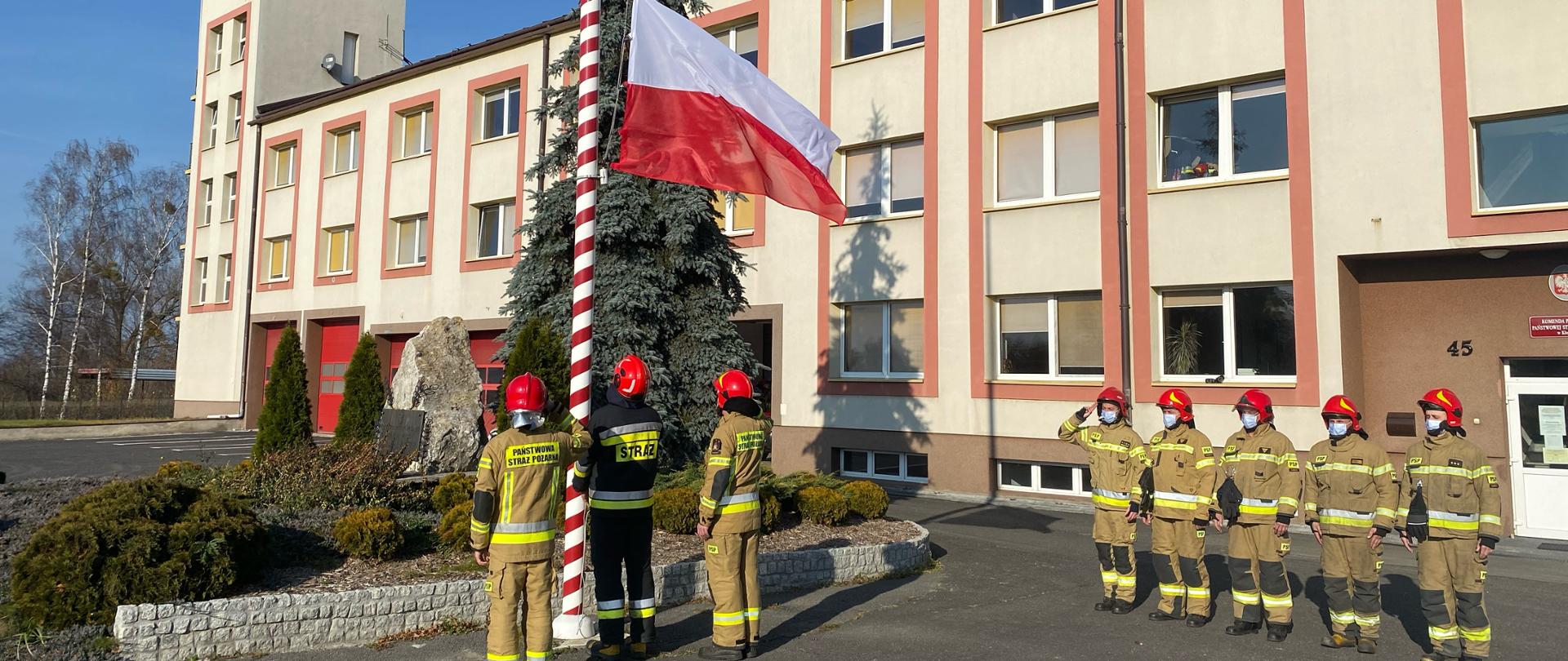 Zdjęcie przedstawia podniesienie flagi państwowej oraz wspólne odśpiewanie hymnu przez strażaków KP PSP w Kłobucku