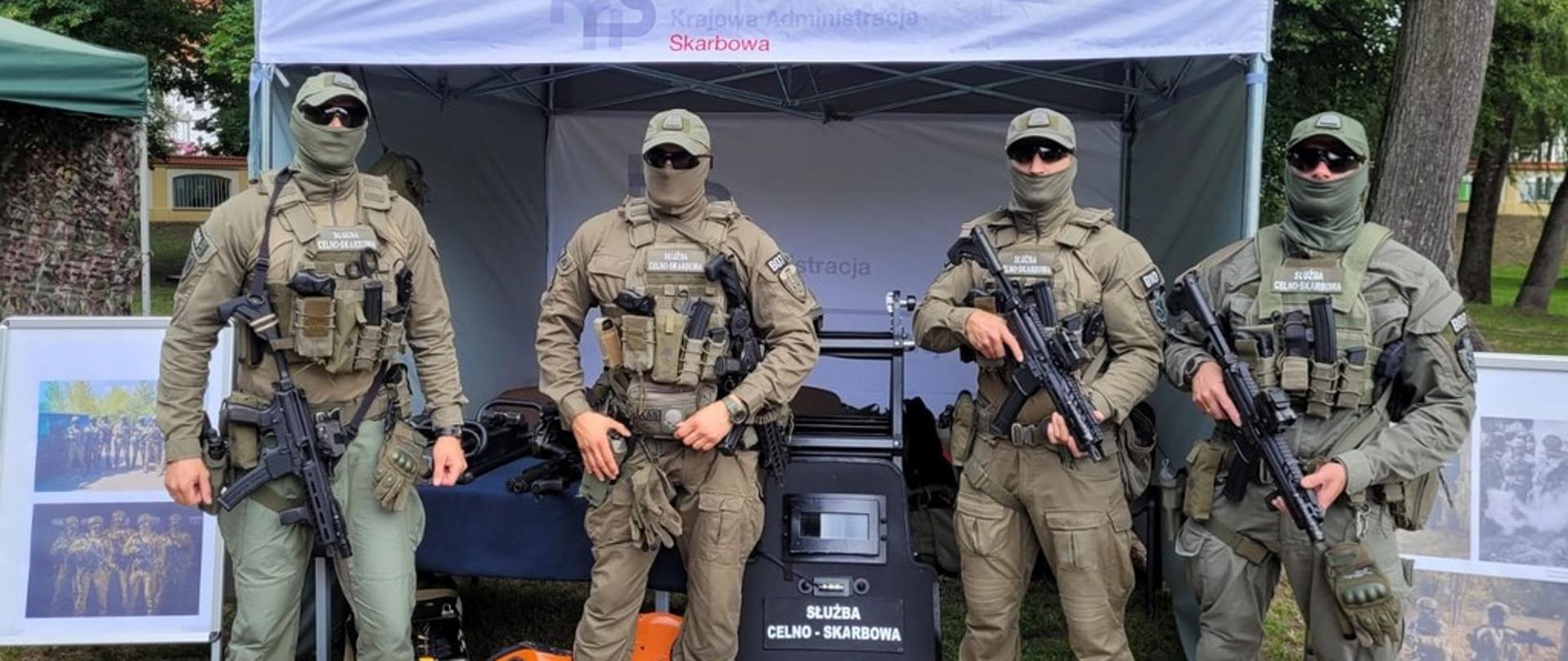 Uzbrojeni funkcjonariusze przed stoiskiem promocyjnym