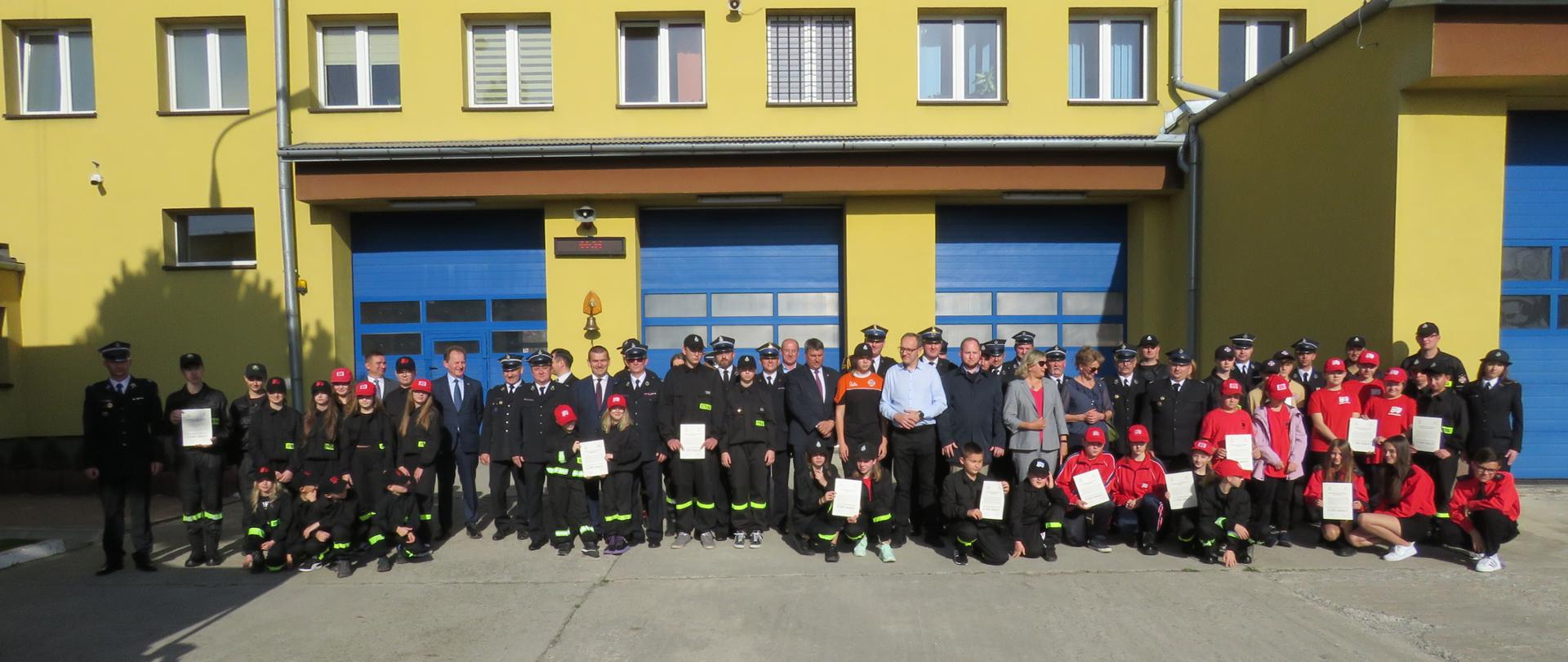 Młodzież MDP oraz wręczający stoją w grupie i pozują do wspólnego zdjęcia