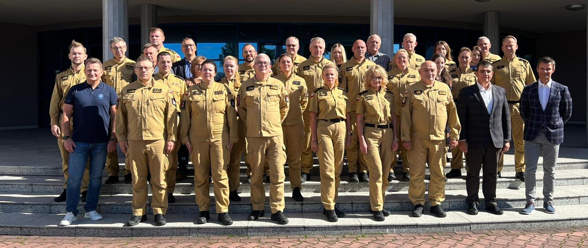 Pamiątkowe zdjęcie funkcjonariuszy PSP oraz pracowników cywilnych będących uczestnikami narady w towarzystwie Komendanta Centralnej Szkoły Państwowej Straży Pożarnej