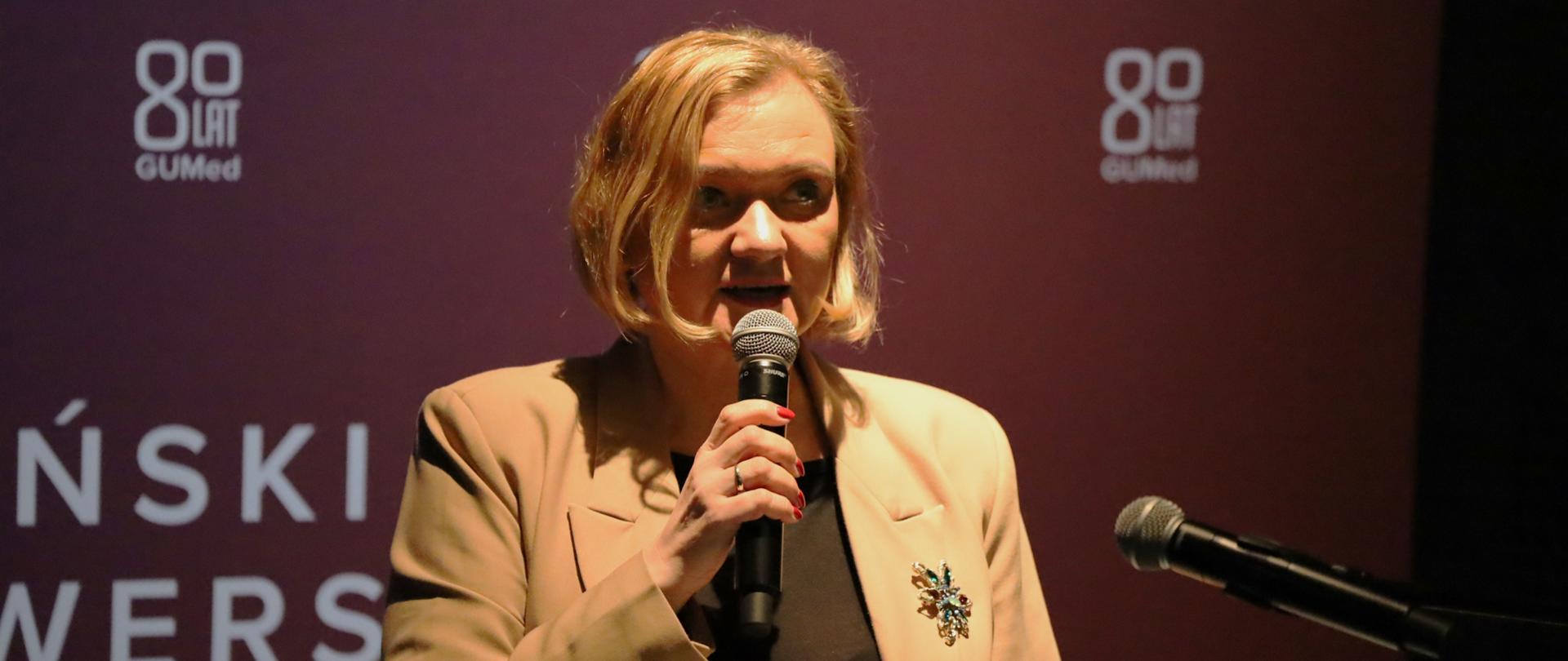 kobieta stoi na scenie i przemawia