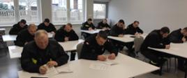 Zdjęcie przedstawia strażaków podczas egzaminu pisemnego szkolenia Naczelników OSP. 
