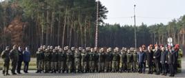 Przedstawiciele policji, Państwowej Straży Pożarnej oraz klasy mundurowej stoją na tle flagi państwowej