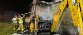 Strażacy gaszą pożar maszyny drogowej