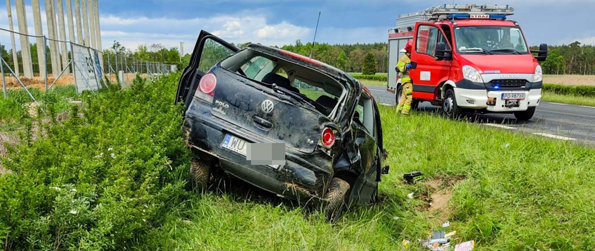 Samochód osobowy w rowie, zastęp JRG ze strażakiem przy drzwiach pojazdu