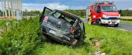 Samochód osobowy w rowie, zastęp JRG ze strażakiem przy drzwiach pojazdu
