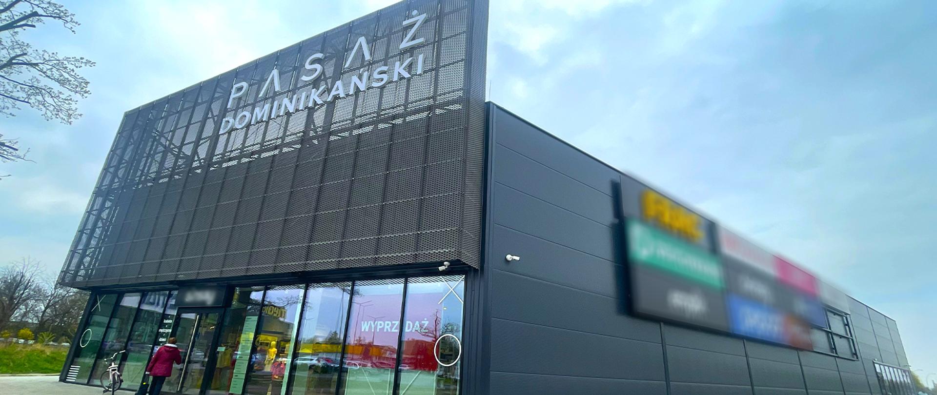 Grafika informacyjna GUNB. Po lewej stronie tekst: „Nowa galeria handlowa w centrum Tarnobrzega z pozwoleniem na użytkowanie”. Po prawej zdjęcia Pasażu Dominikańskiego w Tarnobrzegu - widok budynków galerii handlowej, lokali usługowych oraz centralnego dziedzińca. W prawym górnym rogu hashtag #bezpieczeństwo, w dolnym lewym logo GUNB, w prawym adres gov.pl/gunb.