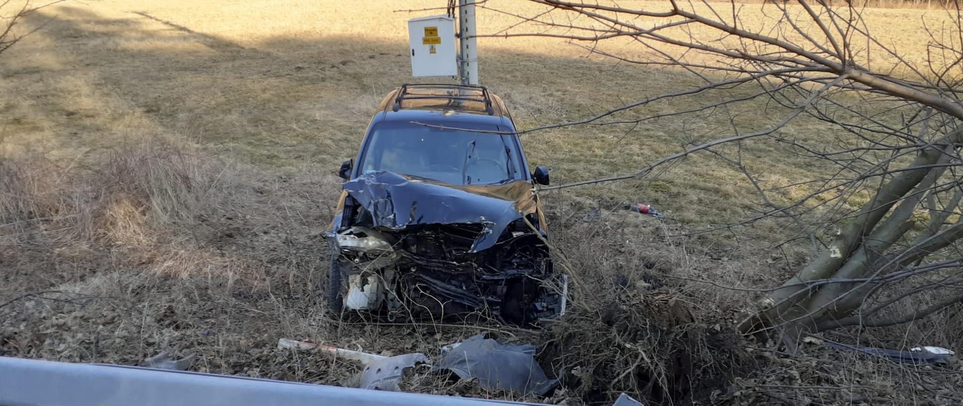 Zniszczony samochód osobowy poza drogą na kołach