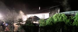 zdjęcie przedstawia pożar budynku gospodarczego w m. Andrespol ul. Teligi (widok z sąsiedniej działki), widoczny zapadający się dach i wydobywająca się para wodna