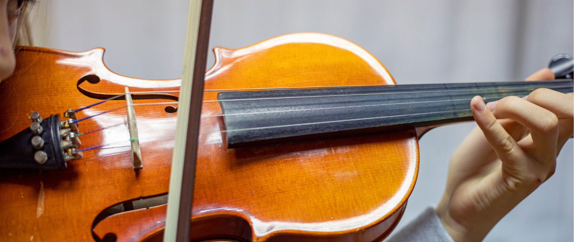 Na plakacie znajduje się zdjęcie skrzypiec oraz dłoń przymierzająca się do gry, nad zdjęciem tekst informujący o warsztatach skrzypcowych prowadzonych przez dr Aleksandrę Kuls - Koziak z Akademii Muzycznej im. Krzysztofa Pendereckiego w Krakowie, oraz informacja – 24 kwietnia 2024, godz. 10:00 Aula PSM, logo PSM w Jaśle oraz motyw dekoracyjny w postaci klucza wiolinowego i nut.