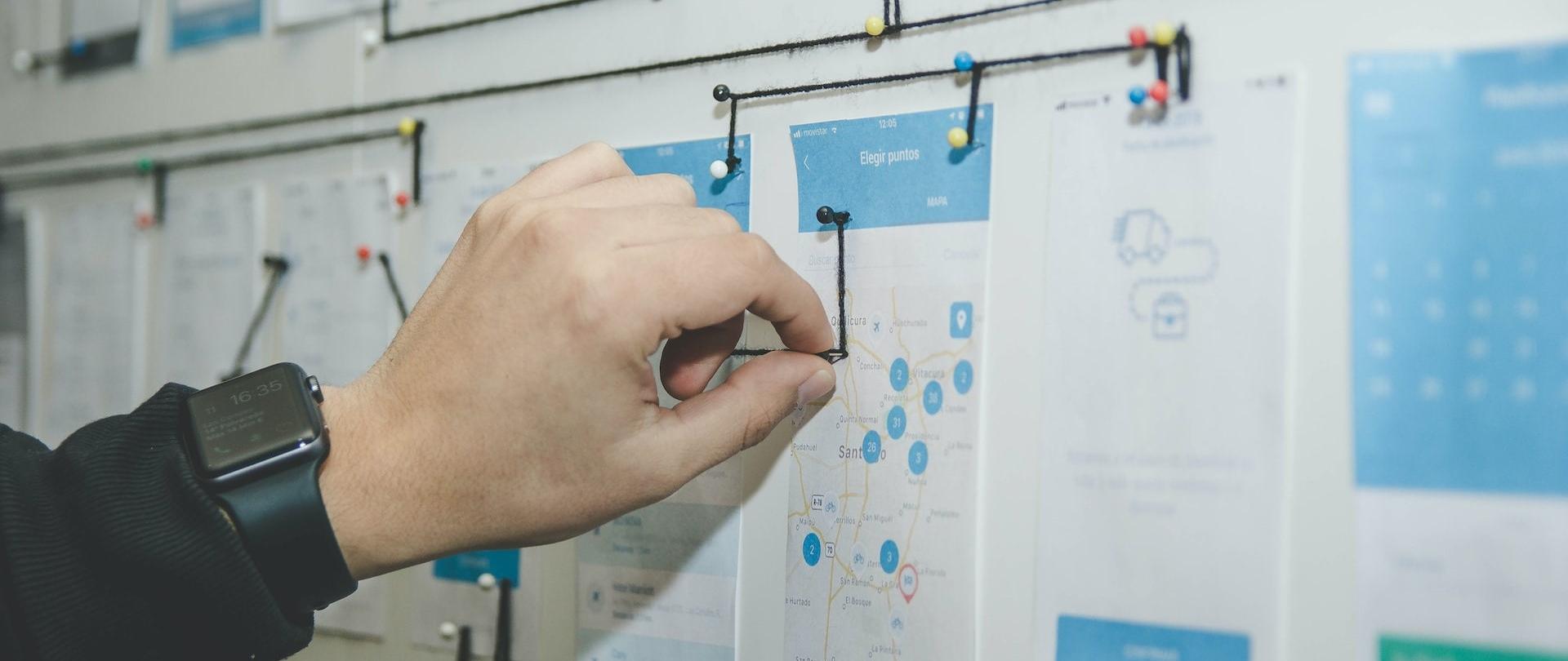 Ręka łącząca rysunki za pomocą nitki i szpilek