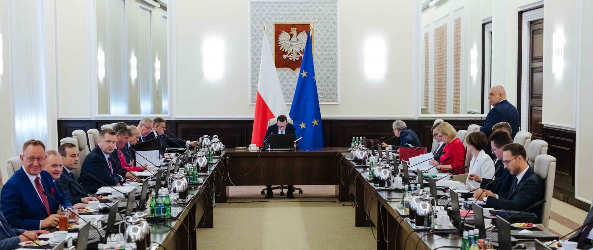 Grupa osób siedzi przy dwóch stołach. Wśród nich jest wiceminister Jadwiga Emilewicz.