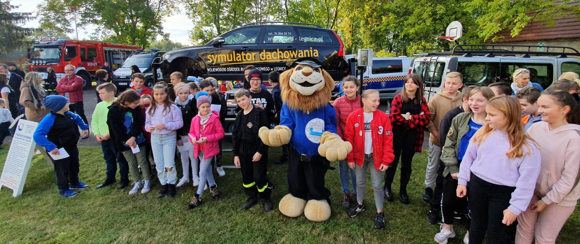 Na zdjęciu widać służby drogowe, służby mundurowe oraz dzieci podczas Pikniku Bezpieczeństwa w Niedźwiedzicach.