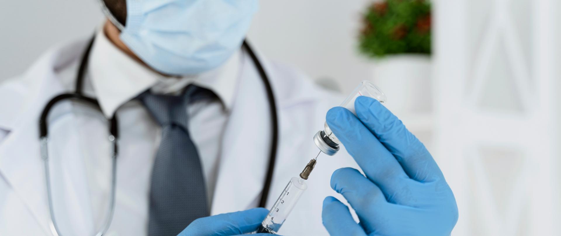 lekarzy trzymający w ręku strzykawkę