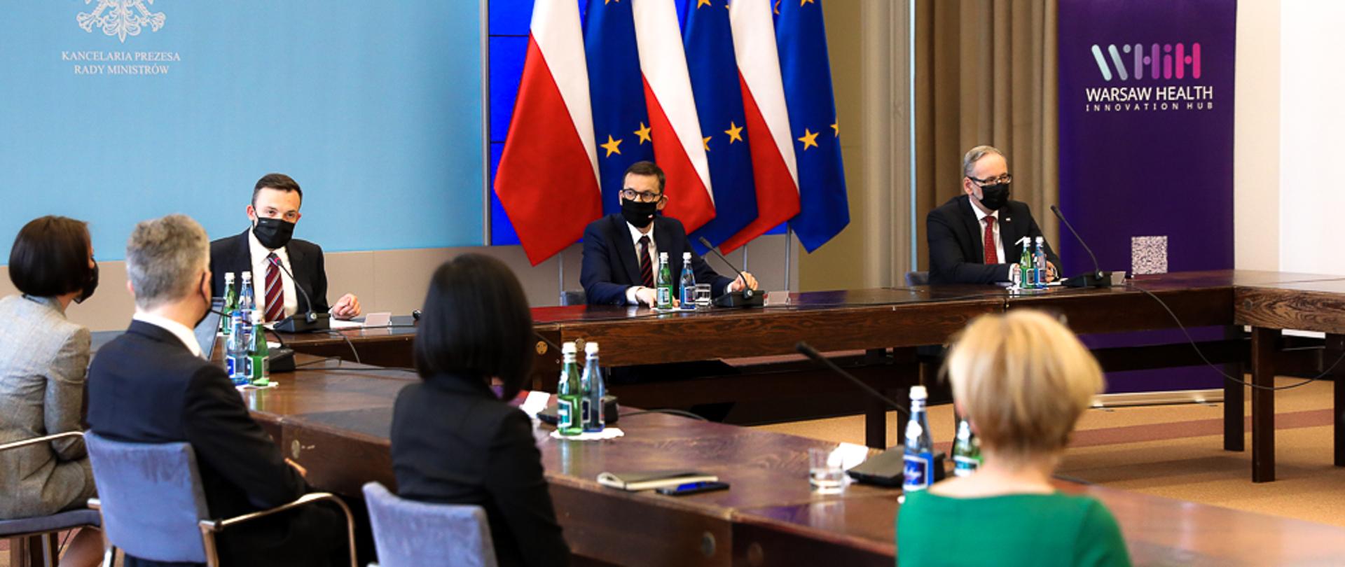 Premier oraz pozostali siedzą przy stole.