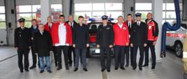 W garażu Komendy Powiatowej Państwowej Straży Pożarnej w Świeciu na tle samochodu Nissan Pickup stoją uczestnicy uroczystości przekazania samochodu dla Wdeckiego Wodnego Ochotniczego Pogotowia Ratunkowego.