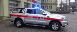 Ford Ranger na tle budynku Komendy Miejskiej PSP w Piotrkowie Tryb.