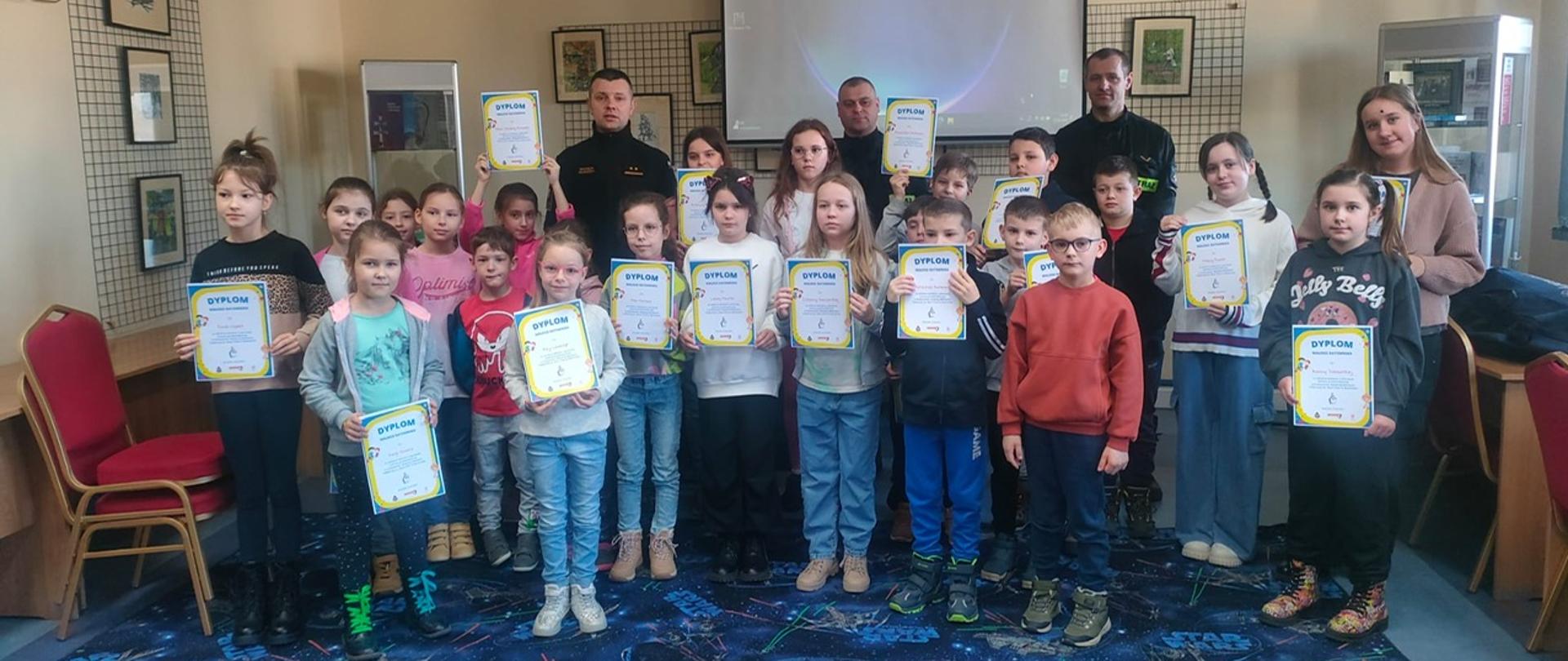 Na zdjęciu funkcjonariusze PSP oraz dzieci i ich opiekunowie po szkoleniu